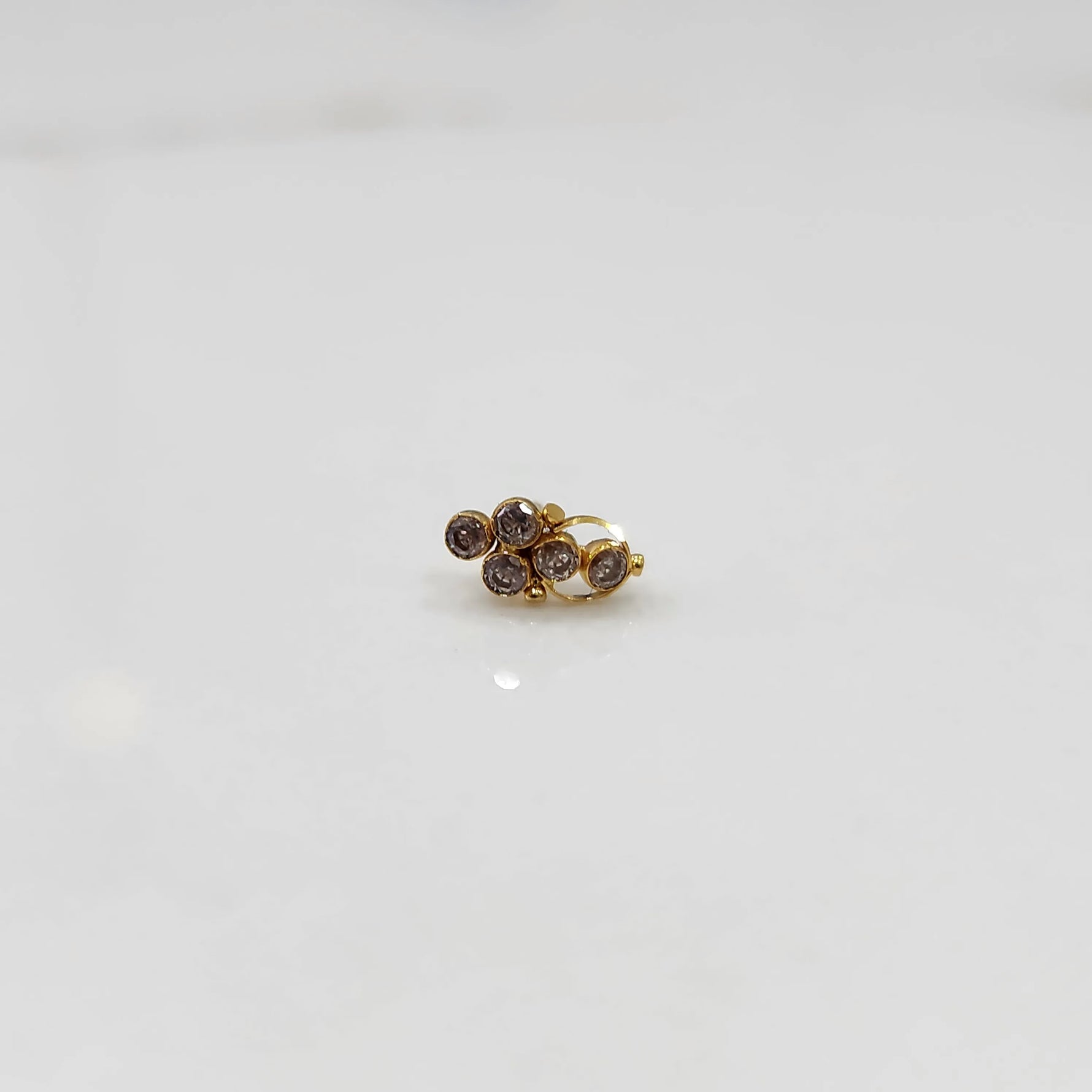 Antique-style gold ring featuring clustered purple-toned gemstones
