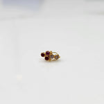 Antique-style gold ring featuring clustered red and clear-toned gemstones