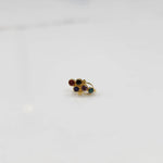 Antique-style gold ring featuring red, green, and purple gemstones grouped together