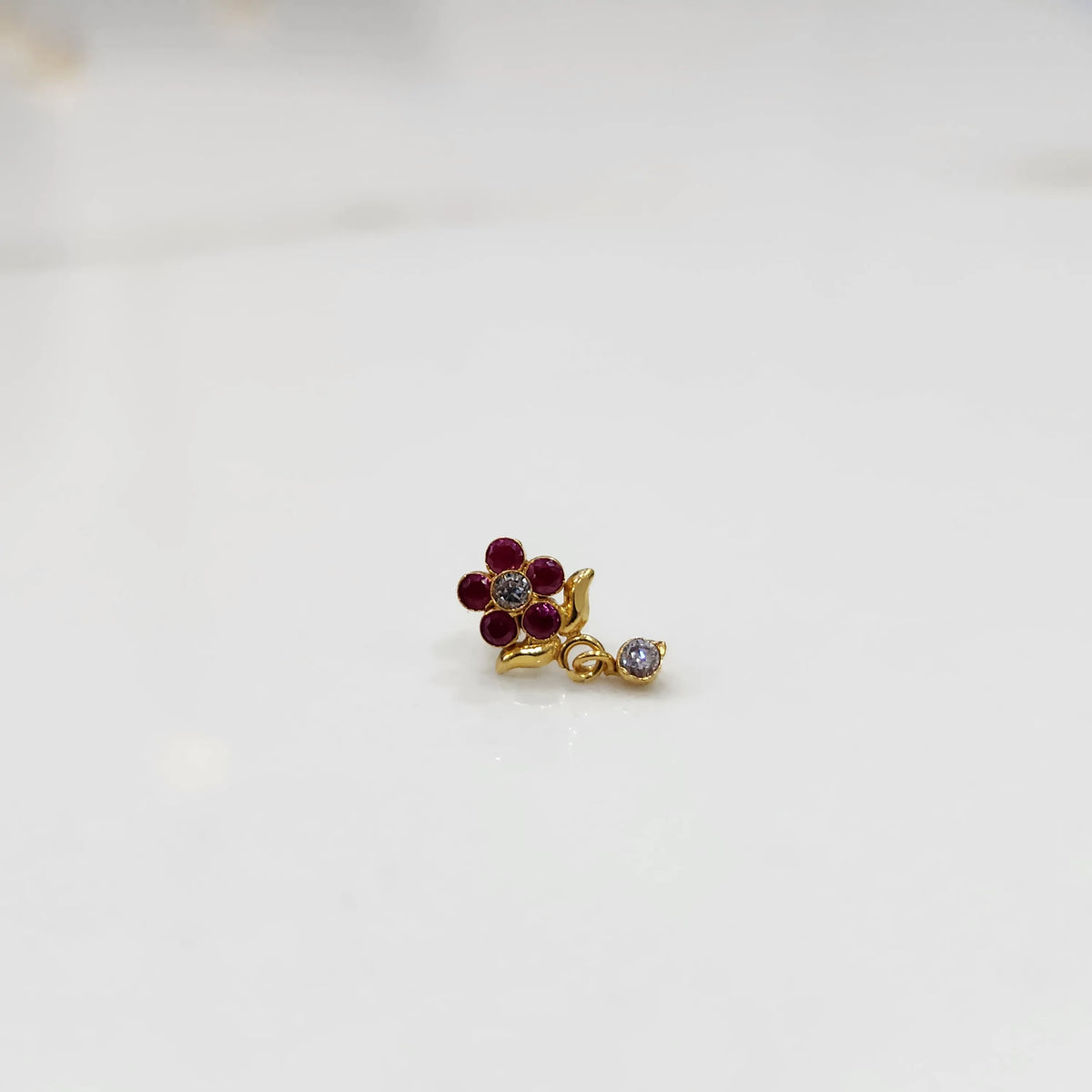 Gold ring with red ruby floral dangle design, side view