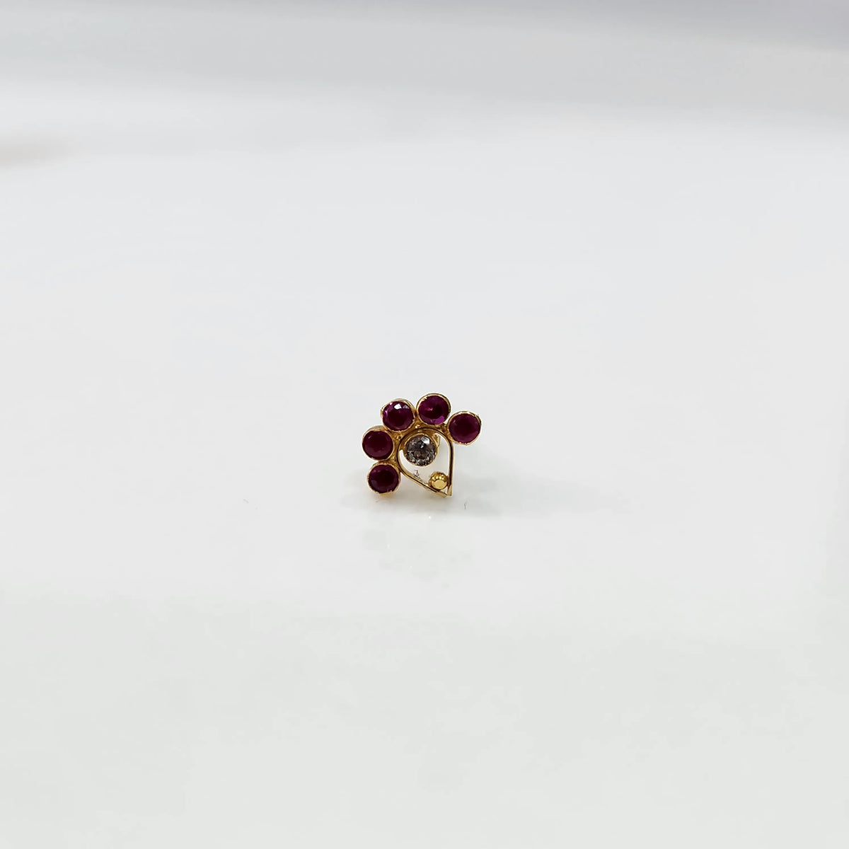 Antique-style gold ring with red-toned stones and CZ center