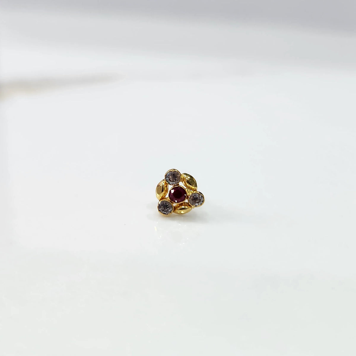 Antique-style gold ring with red-toned stones in leaf-petal pattern