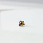 Antique-style gold ring with red-toned stones in leaf-petal pattern