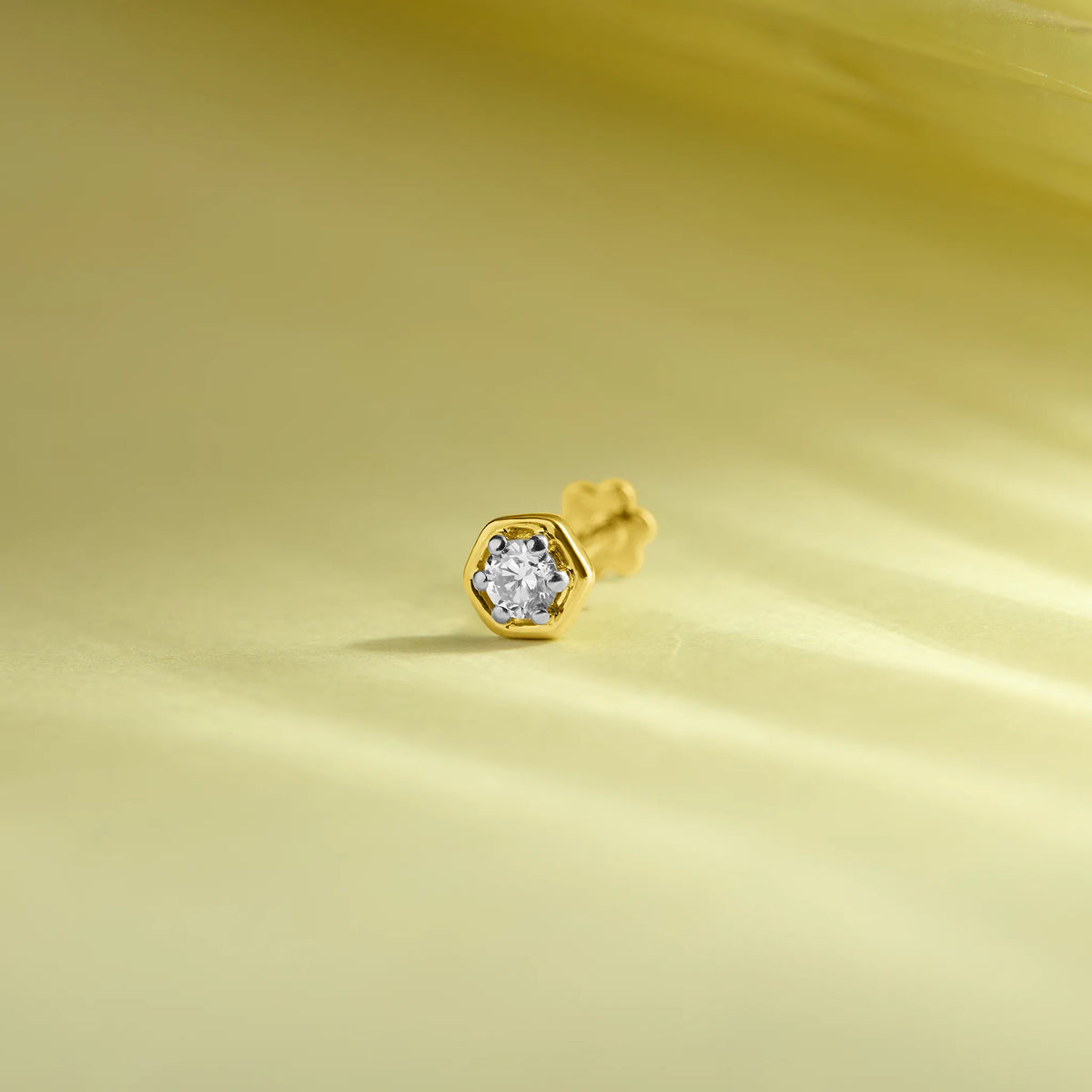 Diamond nose pin design from Kerala in gold on soft pastel background