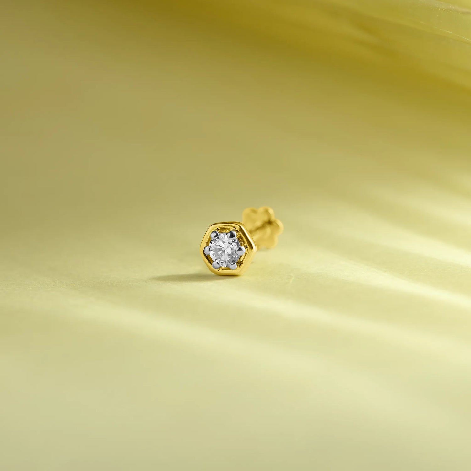 Diamond nose pin design from Kerala in gold on soft pastel background