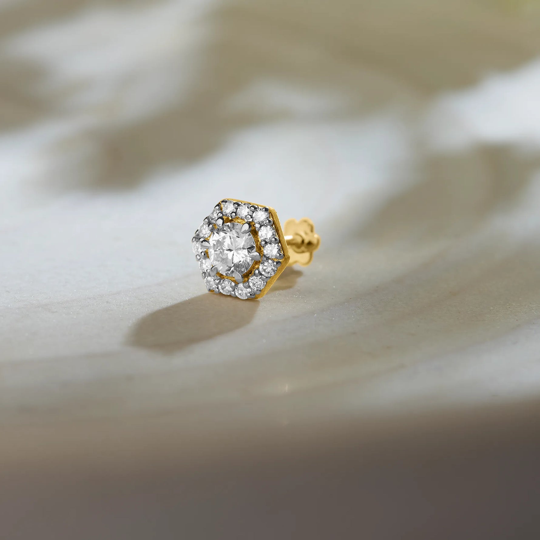 Hexagon halo lab grown gold nose pin with center diamond on soft background