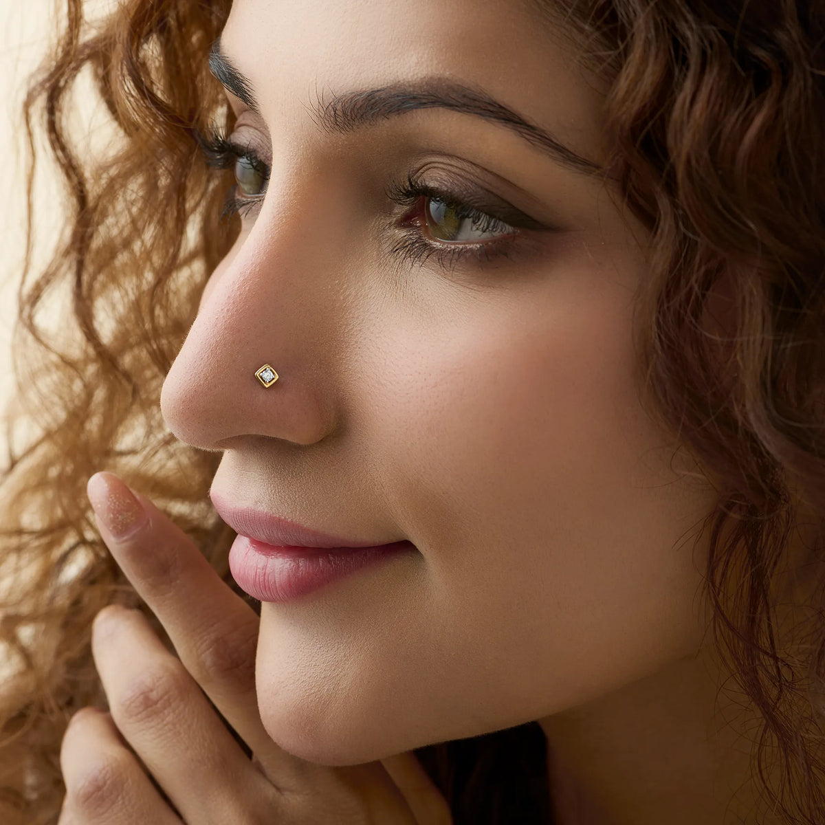 Woman wearing simple gold nose pin close-up portrait