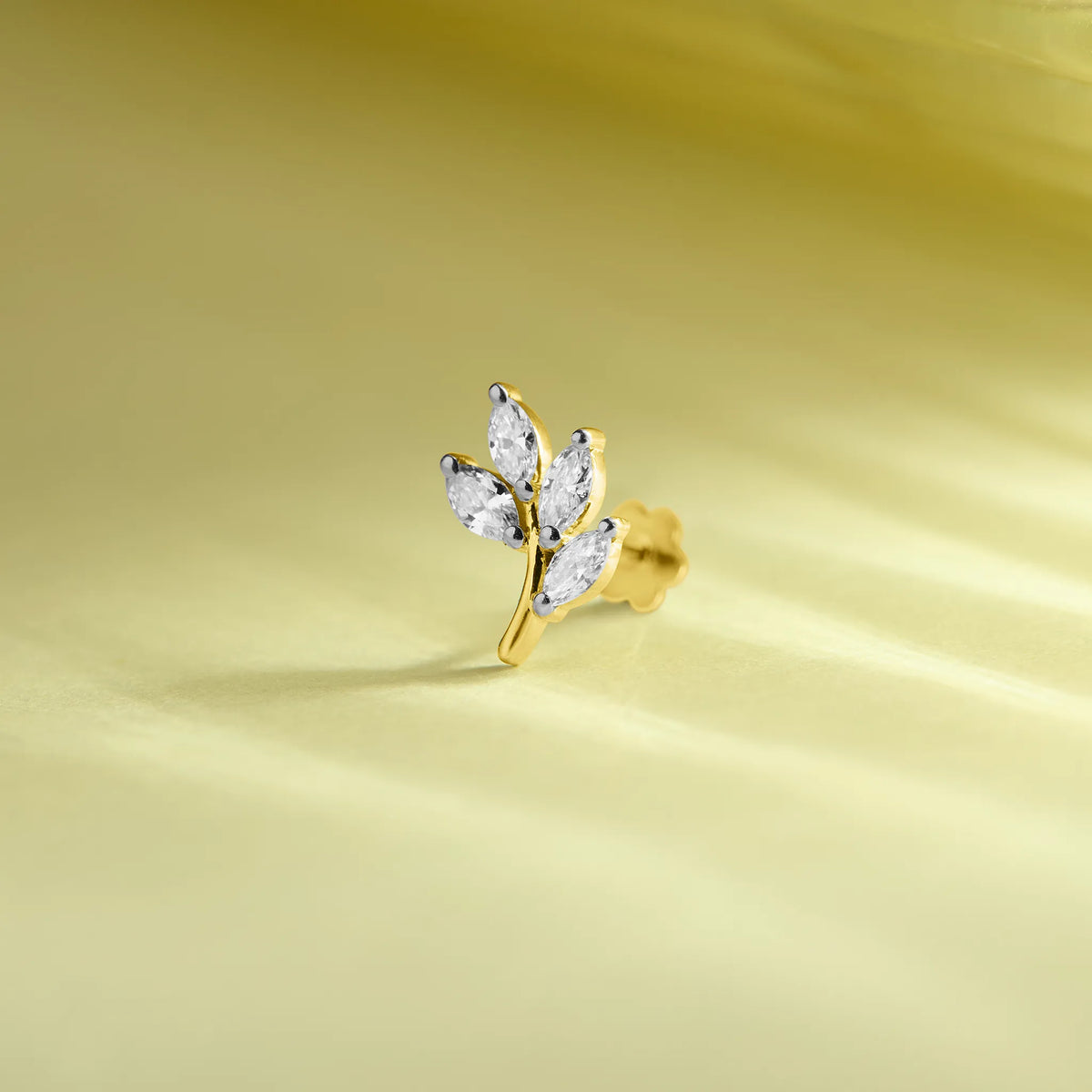14k gold botanical stud earring featuring marquise diamond leaves on a branch