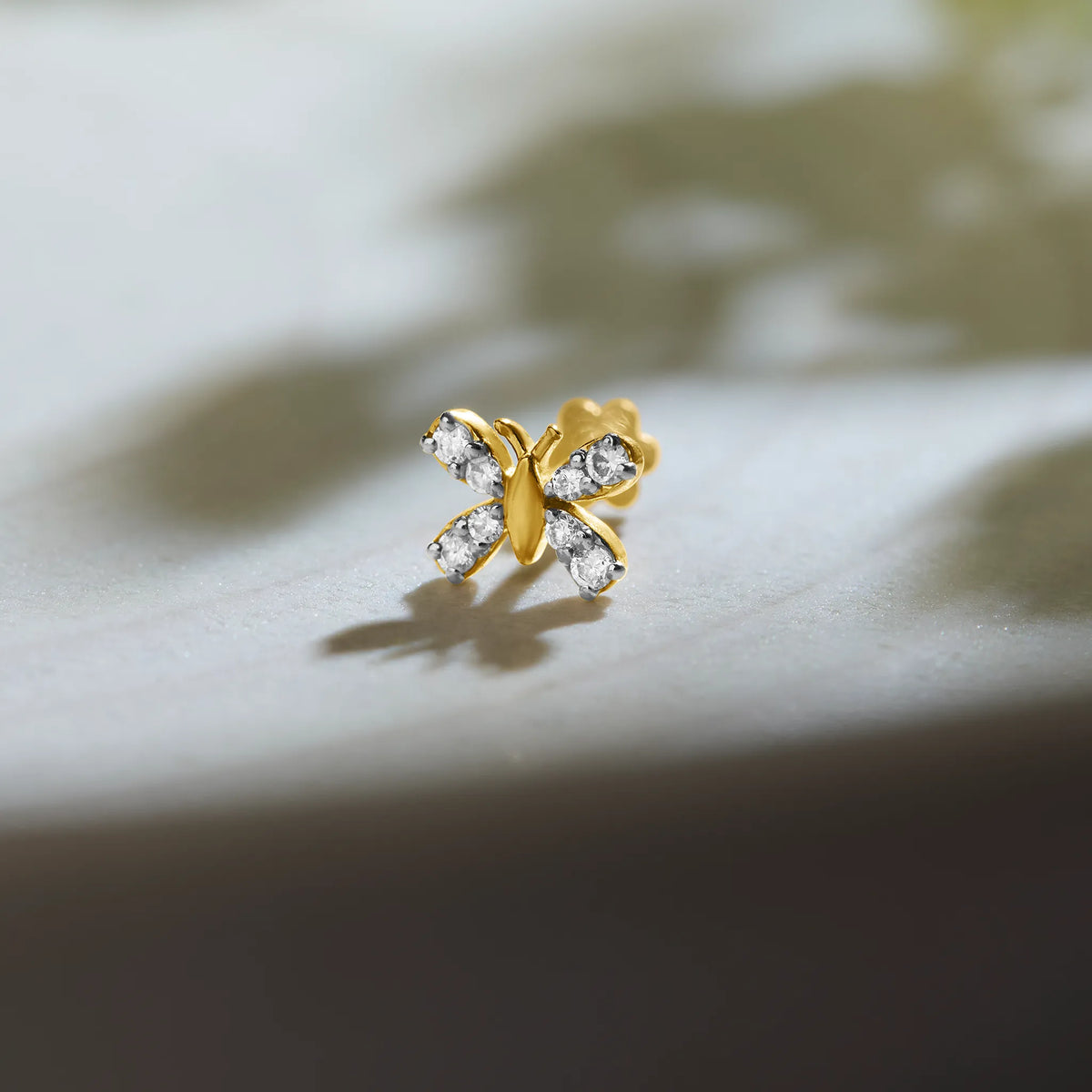 Marquise CZ butterfly stud with pave gold wings, jewelry photography