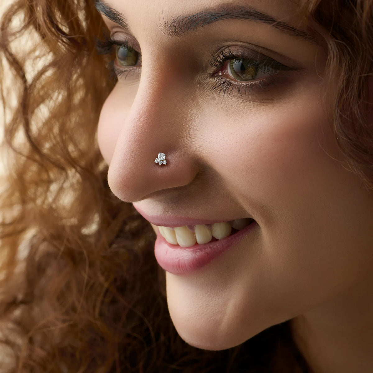 Woman wearing trendy gold floral nose pin close-up portrait