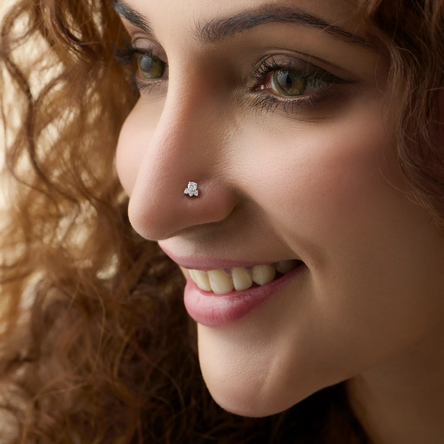 Woman wearing trendy gold floral nose pin close-up portrait