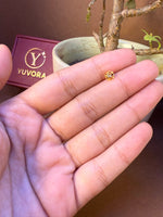 Small round gold flower nose pin with plain finish held in hand, Yuvora jewelry box in background