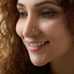 Close-up of woman wearing a nose stud with a small orchid-style diamond design