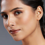 Woman wearing minimal single stone gold nose stud close-up