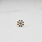 Product shot of a gold nose stud with nine multicolor navratna gemstones