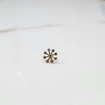 Product shot of a gold nose stud with a nine-diamond sunburst flower design