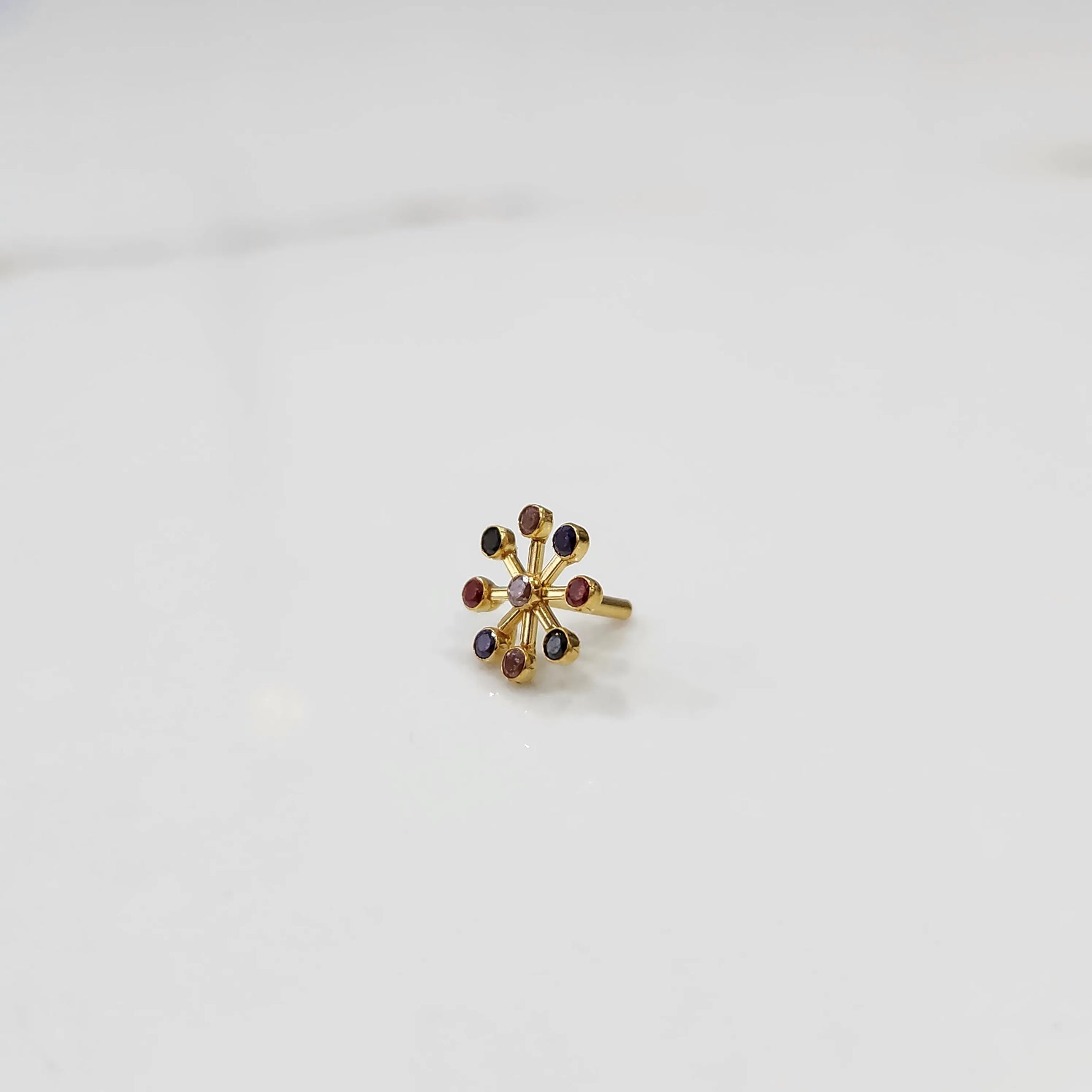 Traditional navratna nose pin with colorful gem cluster, jewelry photography