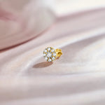 Floral diamond nose pin design from kerala in gold with cluster setting on soft pink background
