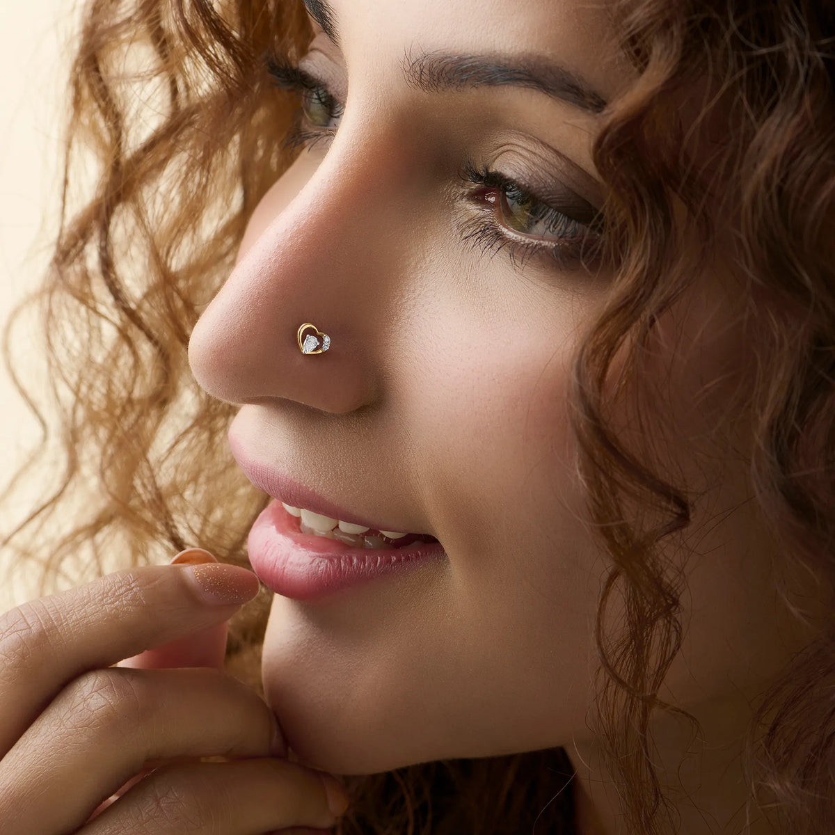 Open heart diamond nose stud worn by a smiling woman, close-up beauty shot