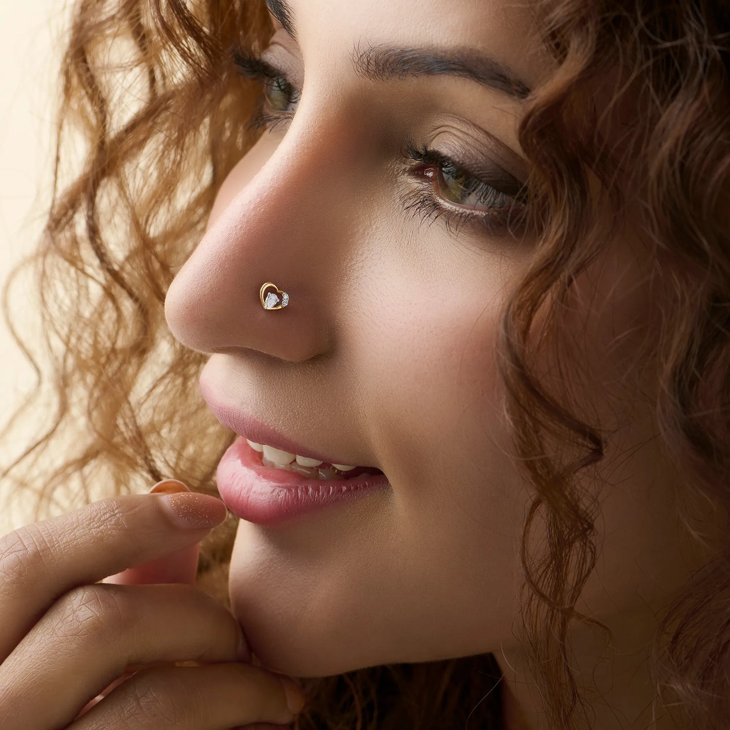 Open heart diamond nose stud worn by a smiling woman, close-up beauty shot