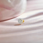 Product shot of a gold nose stud with a round dome-shaped gemstone cluster