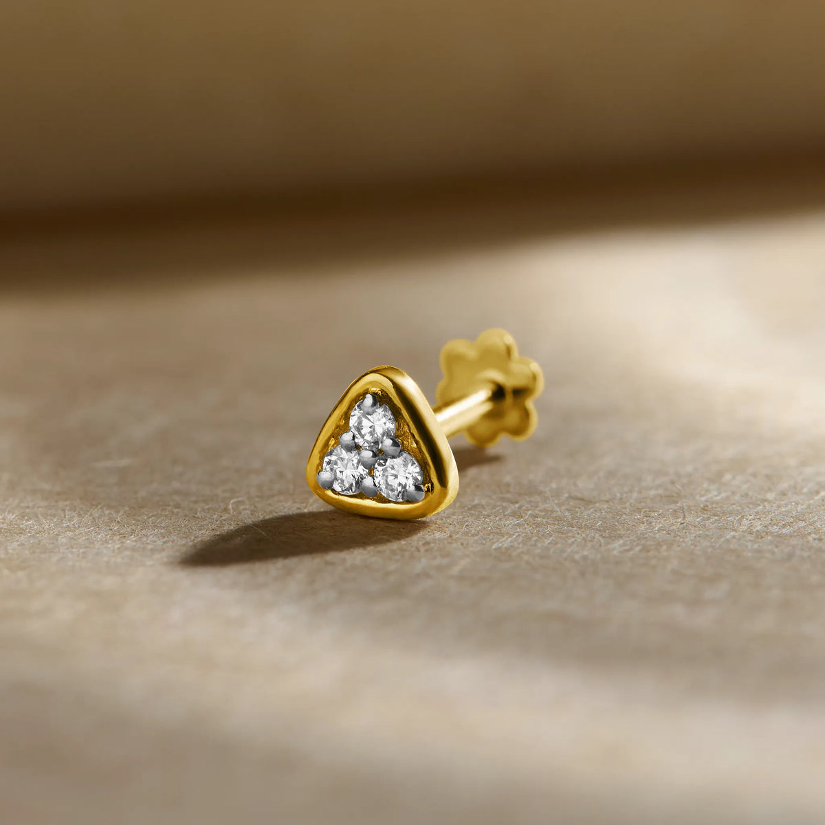 Gold Nose Pin close-up with heart-shaped stone set in polished gold on a soft background