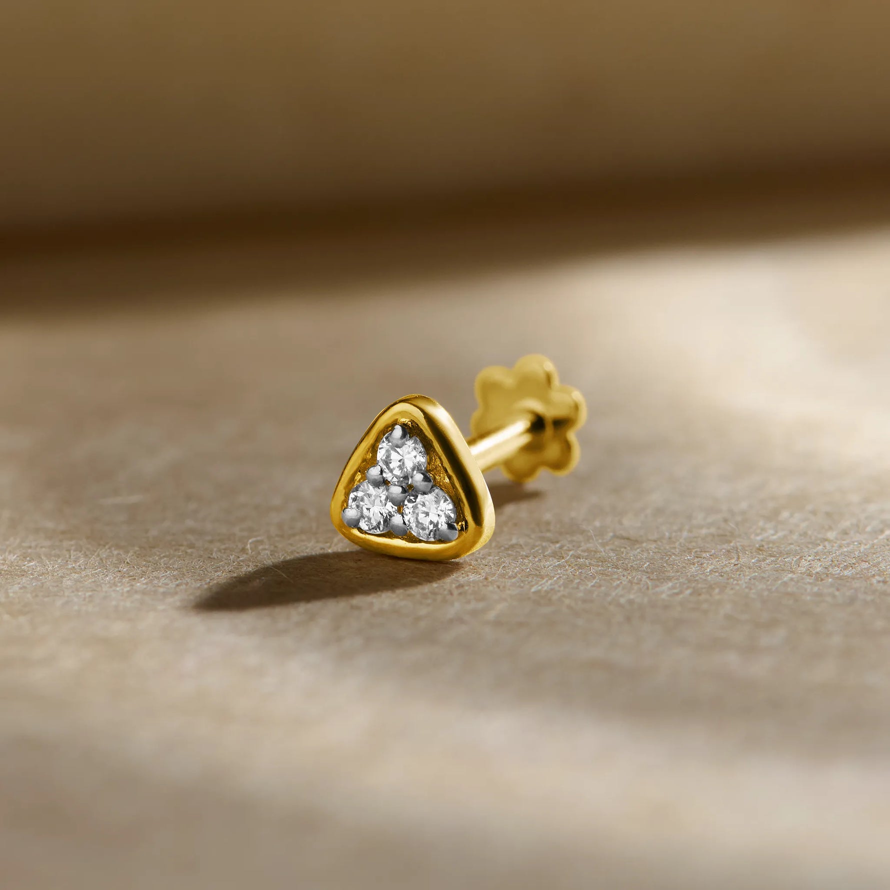 Gold Nose Pin close-up with heart-shaped stone set in polished gold on a soft background