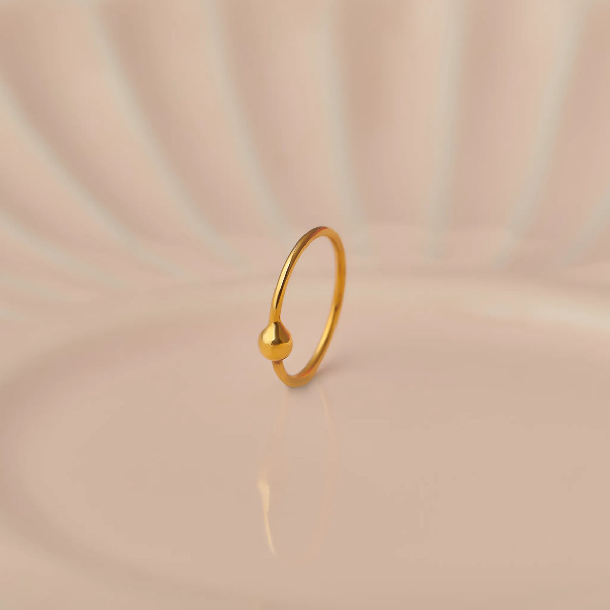 Plain gold hoop earring with small ball closure