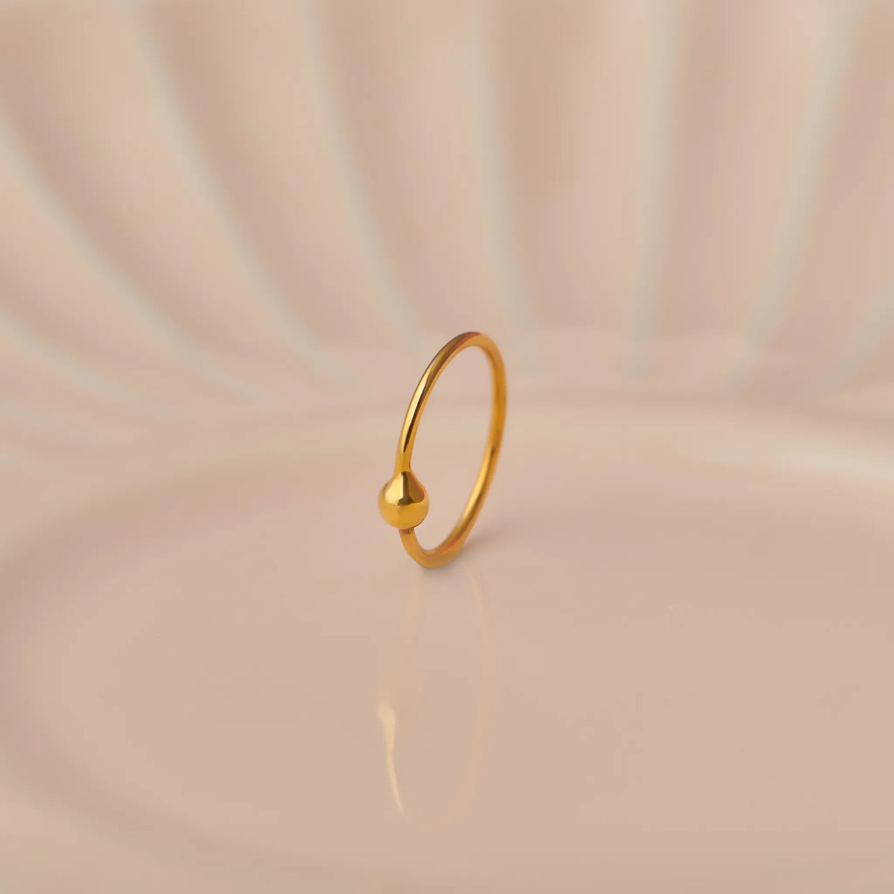 Plain gold hoop earring with small ball closure