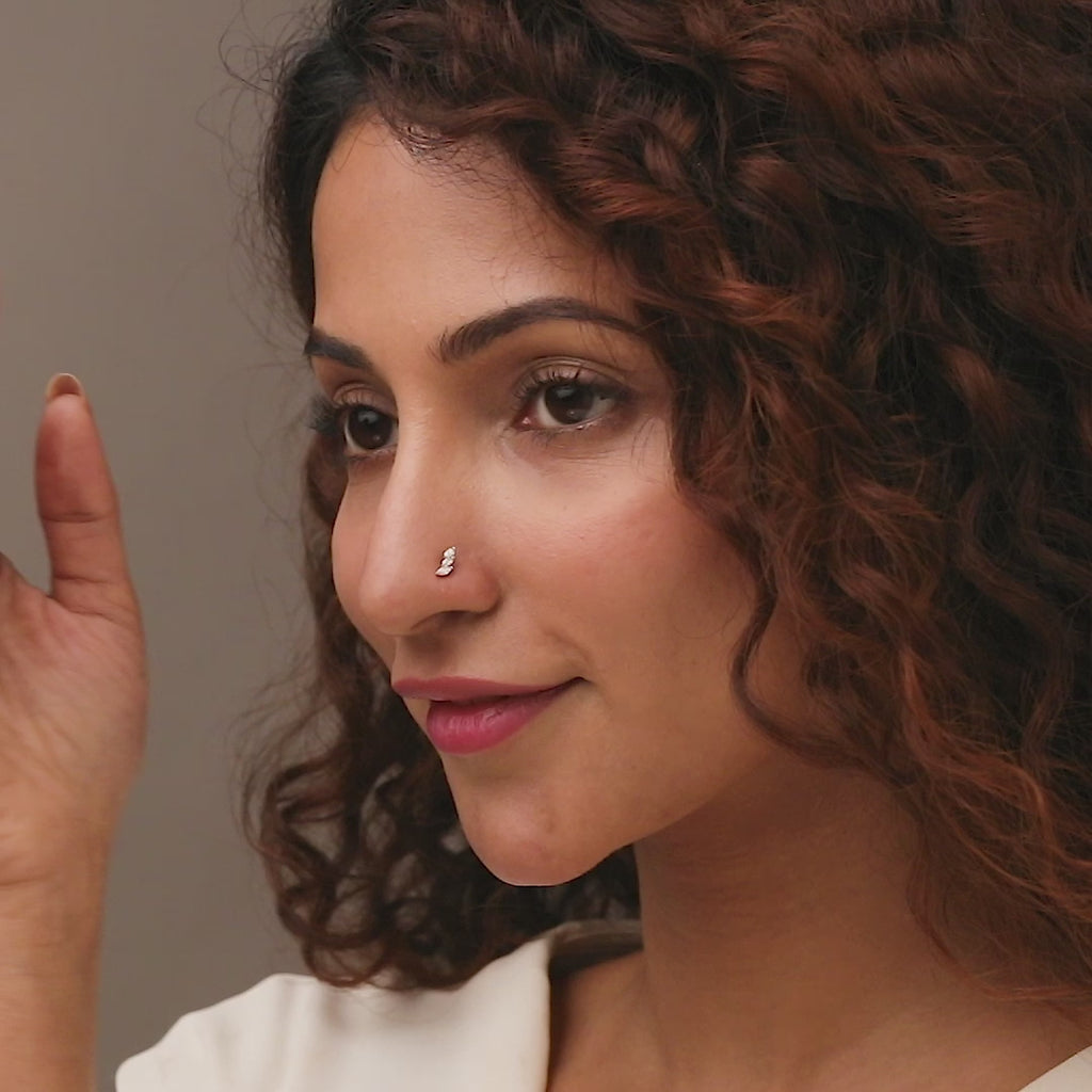 Gold nose pin worn on the nose in a close-up portrait, highlighting a delicate and elegant everyday jewelry look