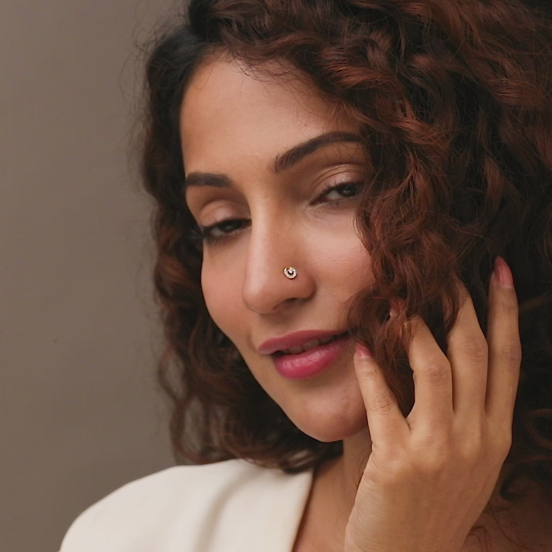 Gold nose pin worn on the nose in a close-up portrait, showcasing a stylish and elegant everyday jewelry look