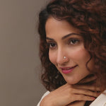 Trending nose pin gold worn on the nose in a close-up portrait, highlighting a classic and elegant everyday jewelry look