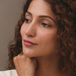 Nose pin gold worn on the nose in a close-up portrait, highlighting a subtle and elegant everyday jewelry style