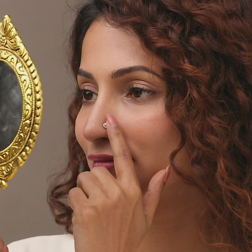 Gold nose pin worn on the nose in a close-up portrait, highlighting a classic and elegant everyday jewelry look