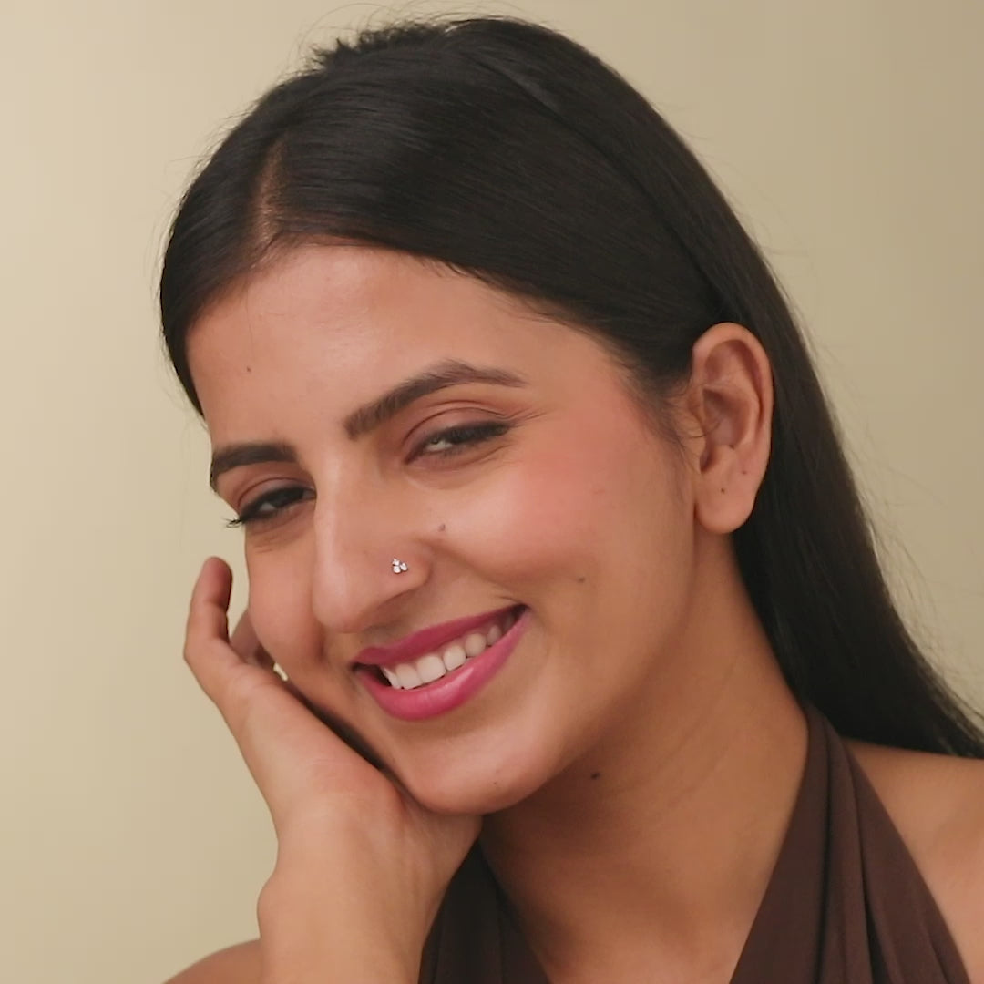 Smiling woman wearing elegant gold nose pin close-up portrait
