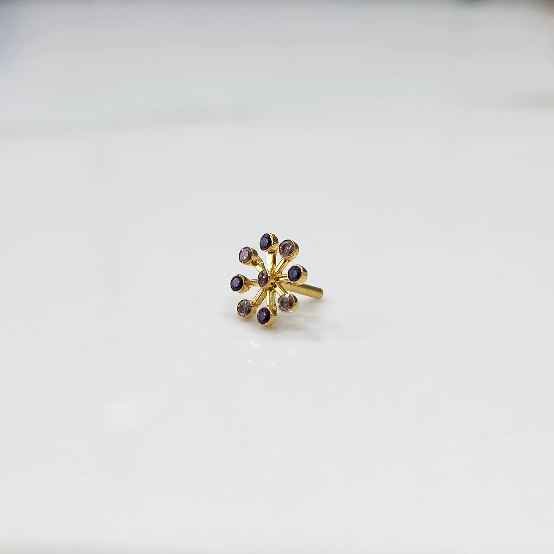 Product shot of a gold flower ring with nine amethyst stones