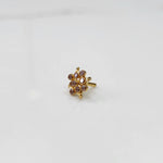 A gold nose pin shaped like a flower, set with soft pink-brown crystal stones