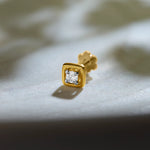 Simple gold square nose pin design with diamond on soft background