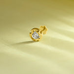 Round diamond stud earring with swirl-shaped gold bezel setting