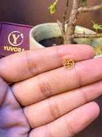 Round gold nose pin with traditional auspicious symbol in beaded border, held in hand