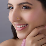 Woman smiling wearing round engraved gold coin nose pin