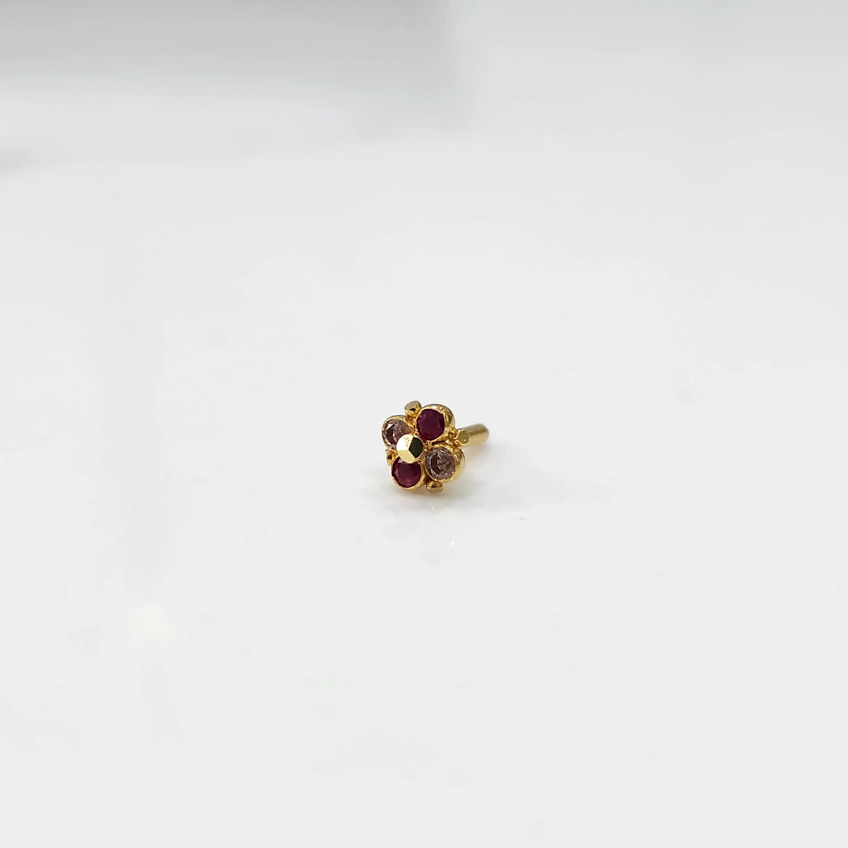 Gold cluster nose pin with ruby and brown stone details