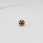 Gold nose pin with ruby center and round stone accents