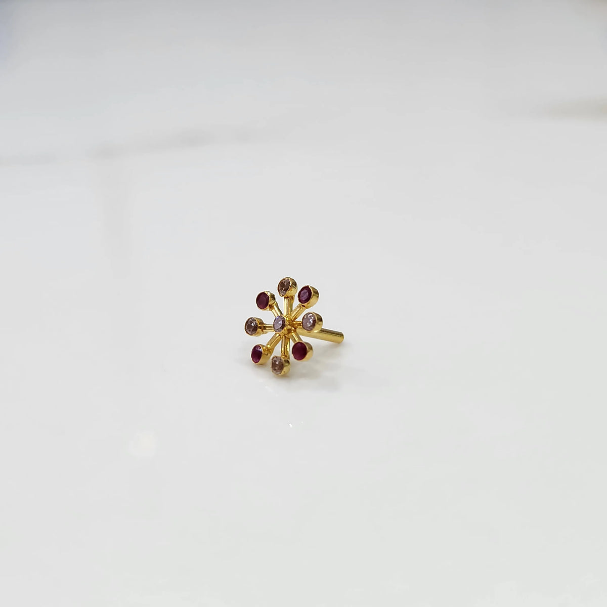 Ruby flower cluster nose pin with gold petal setting, jewelry photography