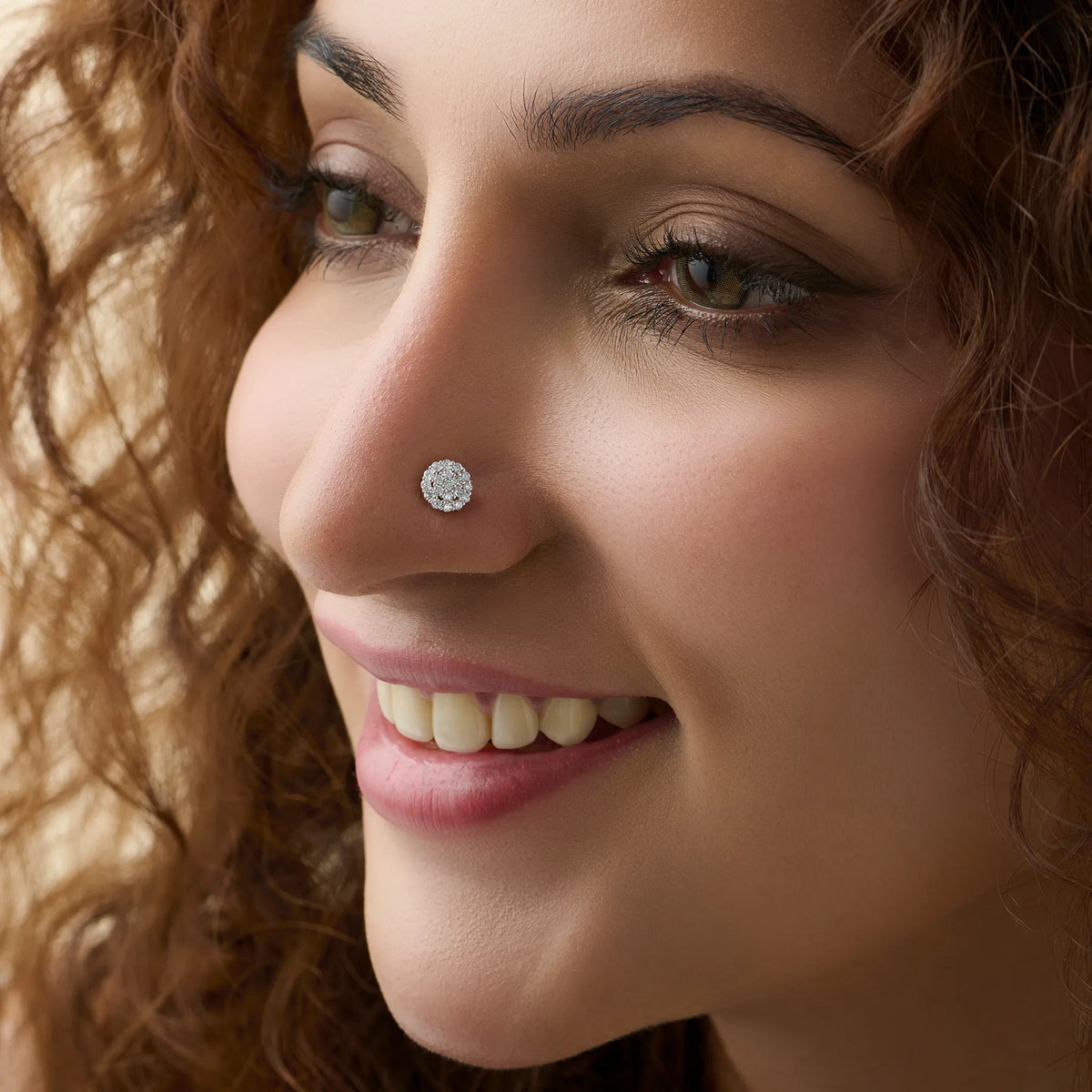 Close-up of woman wearing a silver round pavé stud nose ring