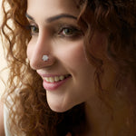 Woman wearing elegant round gold nose pins with sparkling diamond design