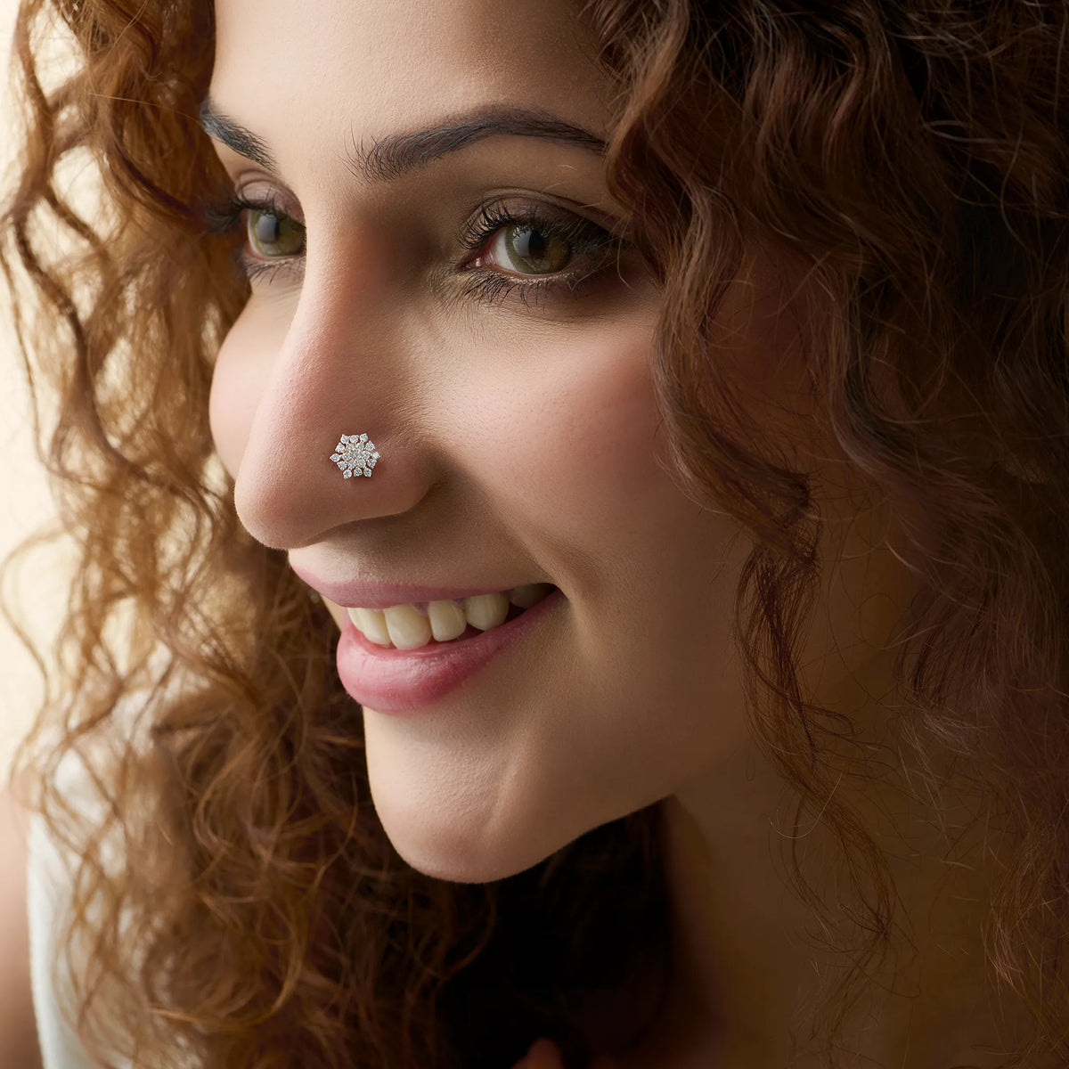 Woman wearing elegant round gold nose pins with sparkling diamond design