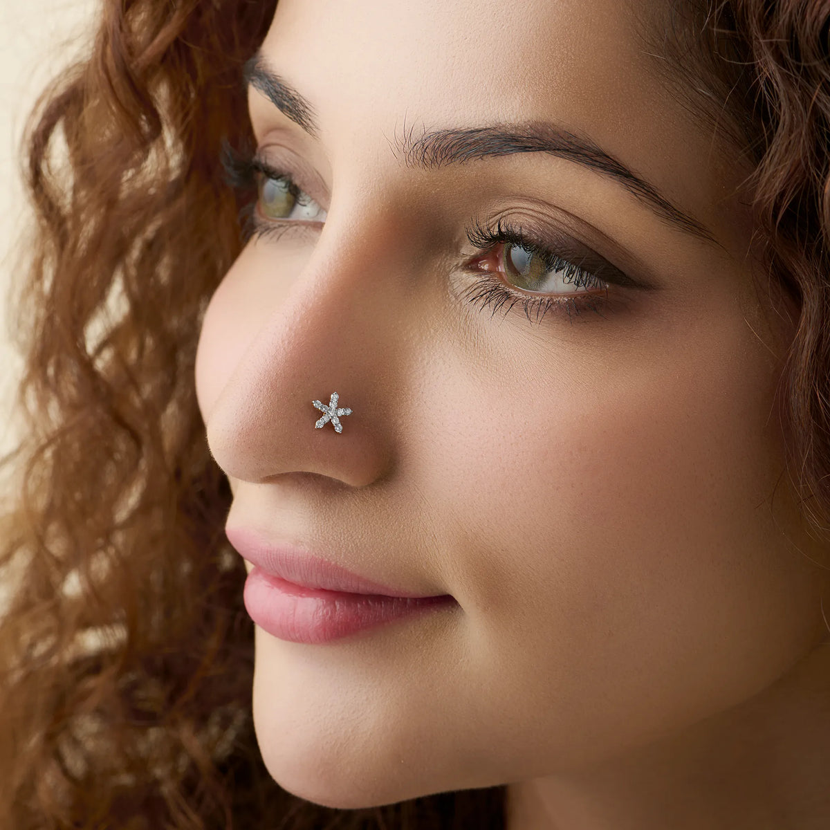 Woman wearing nose pin of gold with elegant star diamond style
