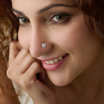 Close-up of woman wearing a silver snowflake-shaped nose ring, hand near chin