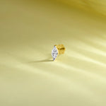 Single stone nose pin gold with marquise diamond solitaire design on soft yellow background